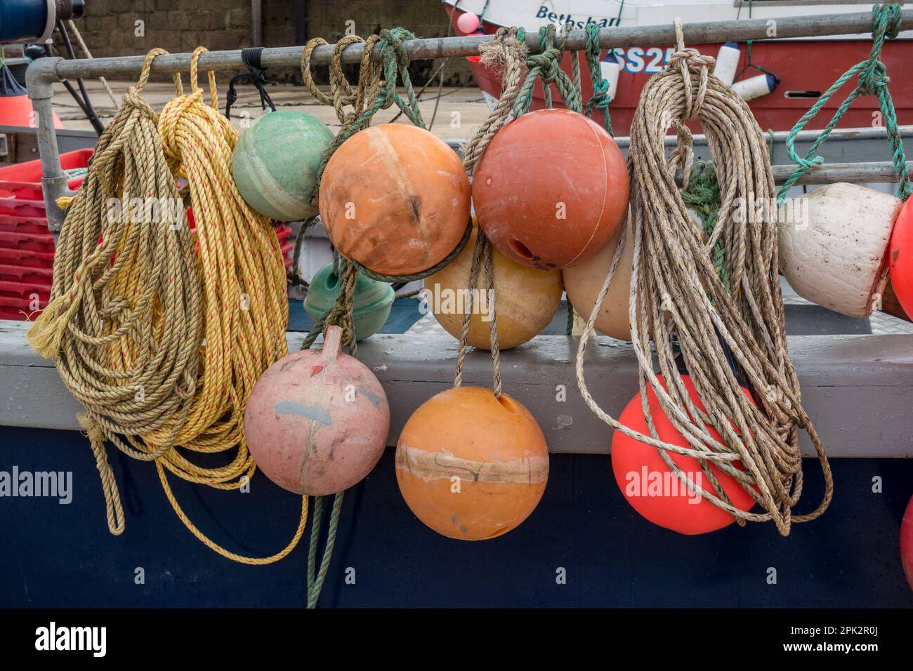 Seile, Schwimmer und Bojen, Angelausrüstung an der Seite eines Bootes in St. Ives Harbour, Cornwall, England, Großbritannien Stockfoto