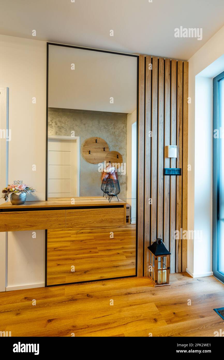 Eine Kleiderschranktür aus Holz mit einem durchgehenden reflektierenden Spiegel, der daran befestigt ist, perfekt für Schlafzimmer oder Ankleidezimmer Stockfoto