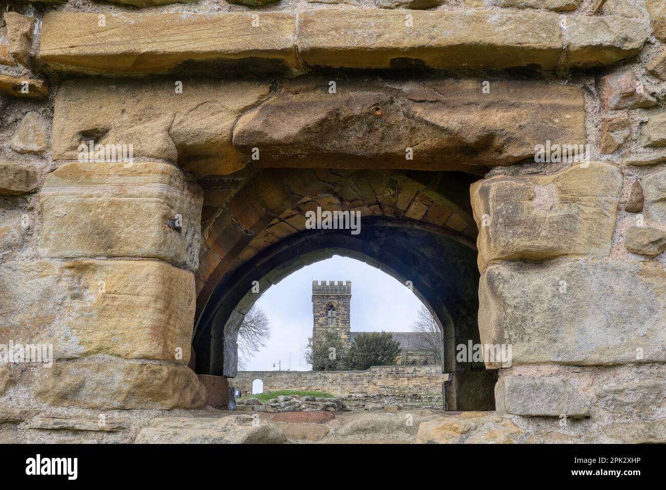 Durch ein Fenster der alten Priory zur aktuellen Kirche in Guisborough Stockfoto