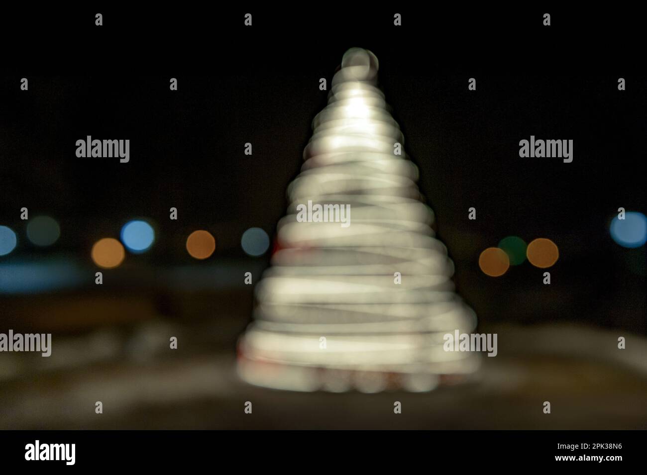 Unschärfe-Lichter spiralförmigen Weihnachtsbaum mit Bokeh auf dunklem Hintergrund. Neues Jahr. Stockfoto