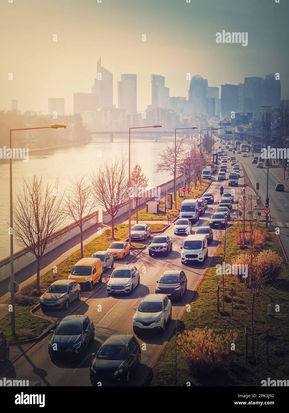 Viel Verkehr auf der Autobahn und den Straßen der Stadt verursacht hohe Umweltverschmutzung und Smog. Blick auf den urbanen Sonnenuntergang über die seine zum Stadtviertel La Defense, P Stockfoto