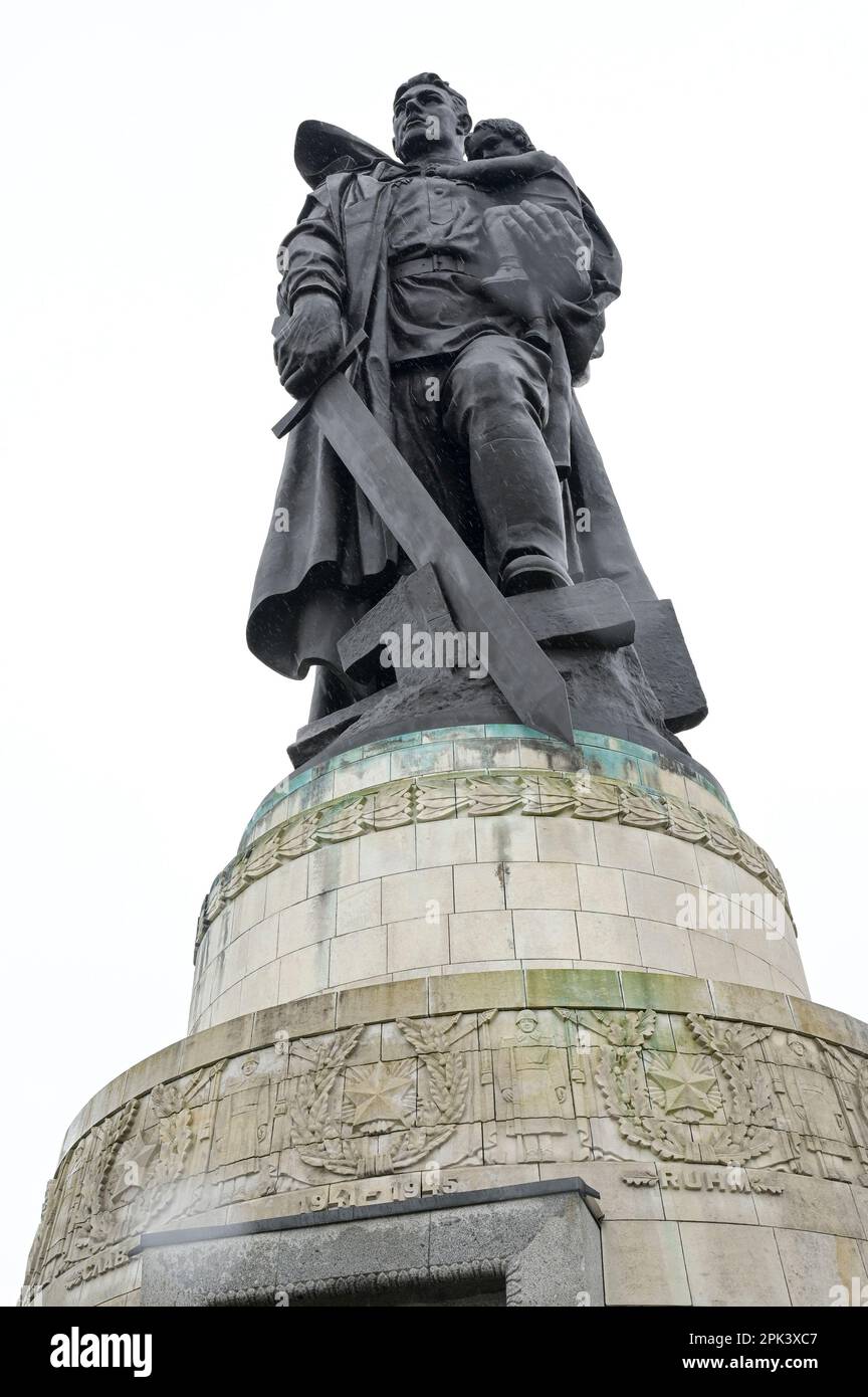 DEUTSCHLAND, ehemaliges Ostberlin, Treptow, sowjetisches Denkmal für den Zweiten Weltkrieg und Soldatenfriedhof mit 7000 Gräbern im Treptower Park, 1946-49 erbaut, Skulptur eines Soldaten mit Kind und Schwert, der die Nazi-Hakenkreuze vernichtet / DEUTSCHLAND, Berlin, Treptower Park, sowjetische Friedenmal und Soldatenfriedhof der Roten Armee im Zweiten Weltkrieg, Skulptur Soldat mit Kind auf dem Arm und mit Schwert zerschlagenes Hakenkreuz Stockfoto