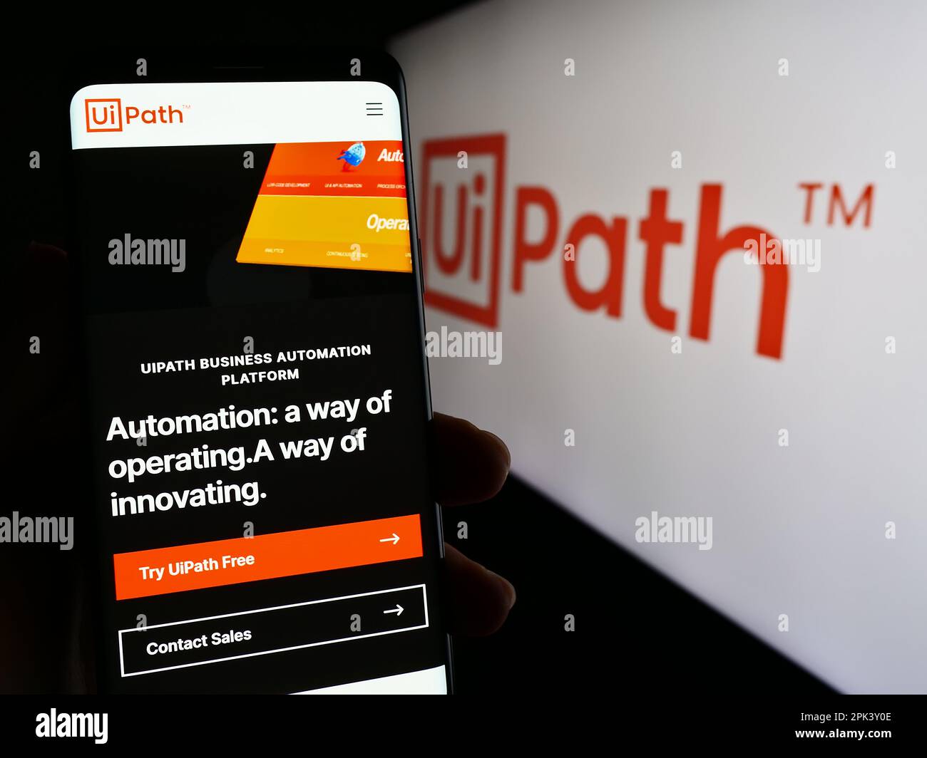Person, die ein Mobiltelefon mit einer Webseite des Automationssoftwareunternehmens UiPath Inc. Auf dem Bildschirm vor dem Logo hält. Konzentrieren Sie sich auf die Mitte des Telefondisplays. Stockfoto