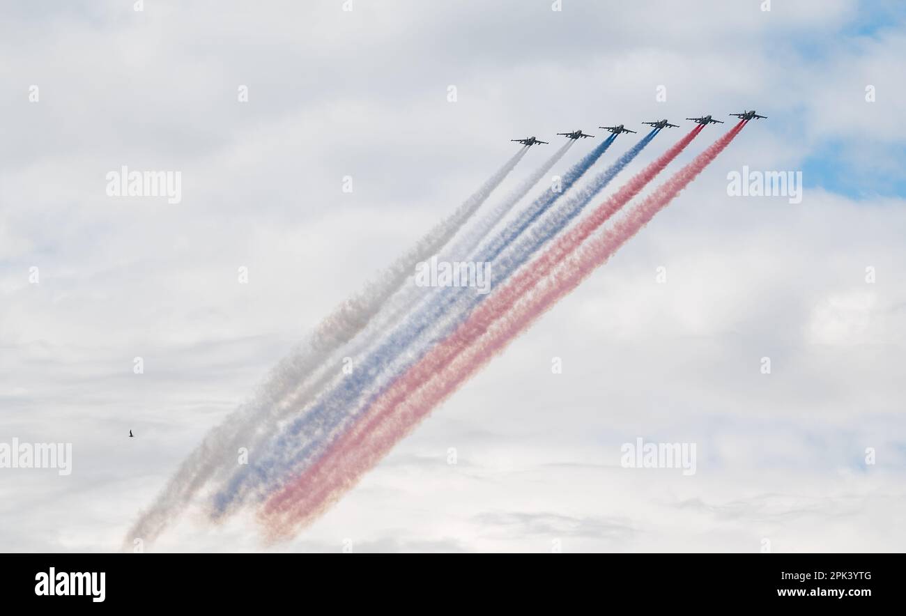 31. Juli 2022, St. Petersburg, Russland. Sukhoi Su-25 greift Flugzeuge an, die bei der Main Naval Parade in Rauch in den Farben der russischen Flagge abgegeben haben Stockfoto
