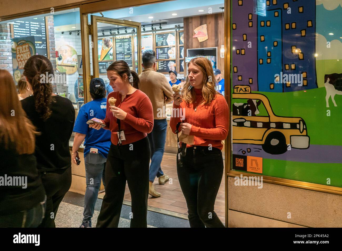 Mitarbeiter im Rockefeller Center verlassen den Ben & Jerry's Eisladen in New York mit ihrem kostenlosen Eis während des kostenlosen Cone Day des Unternehmens am Montag, den 4. April 2023. Das Unternehmen feiert seinen Geburtstag, indem es tausende von Gratiskonus verschenkt (© Richard B. Levine) Stockfoto