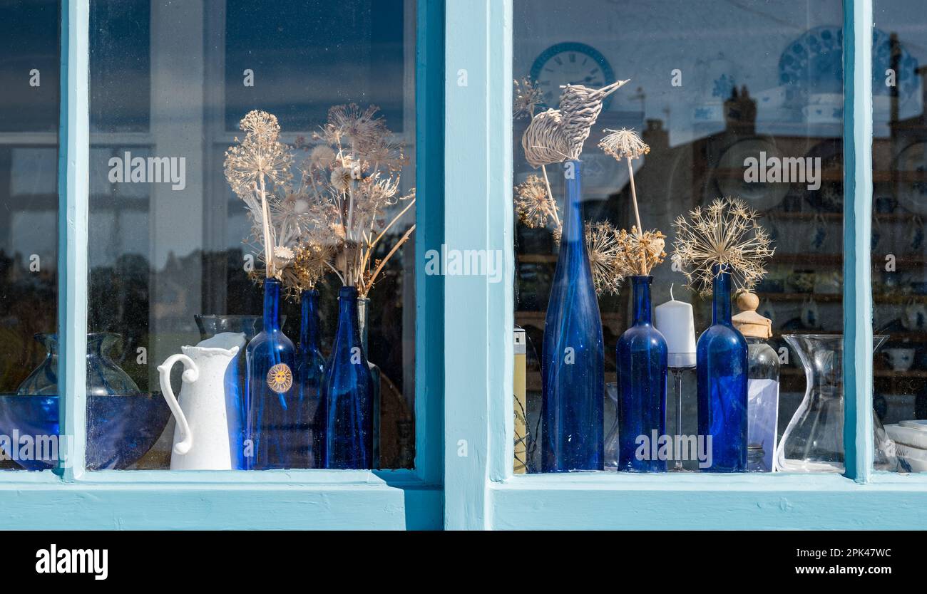Anzeige von blauen Flaschen mit getrockneten Blumen durch das Küchenfenster, North Berwick, East Lothian, Schottland, Großbritannien Stockfoto