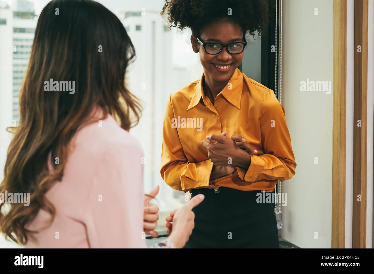 Junge asiatische Geschäftsfrau, die mit einem Kollegen des Unternehmens spricht Stockfoto