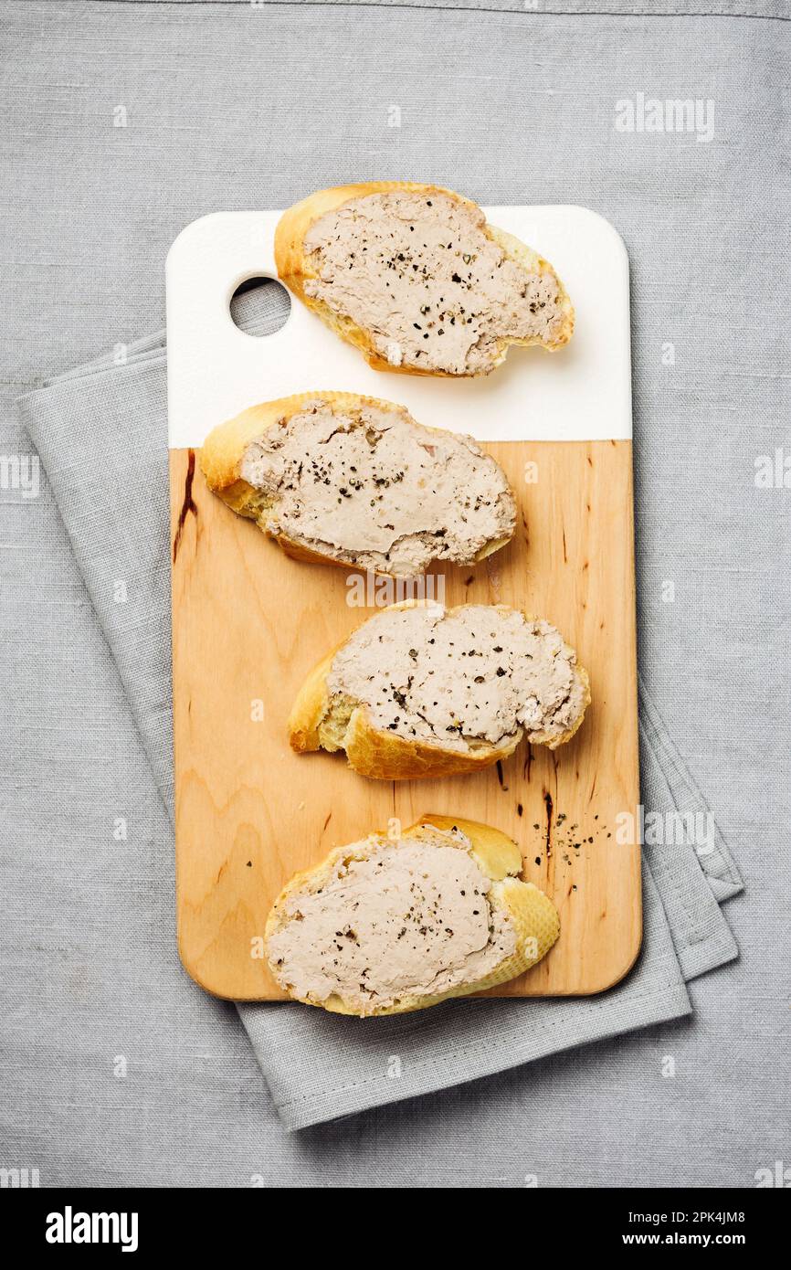 Baguette mit Leberpastete auf einem Leinentischtuch. Stockfoto