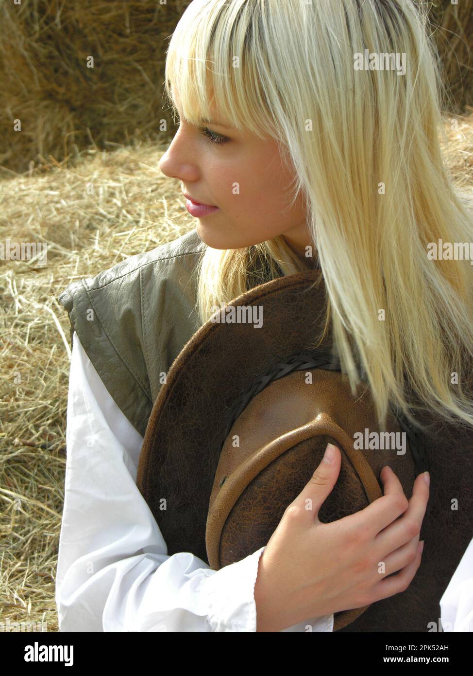 Porträt eines jungen attraktiven Cowgirls auf der Ranch am sonnigen Sommertag Stockfoto