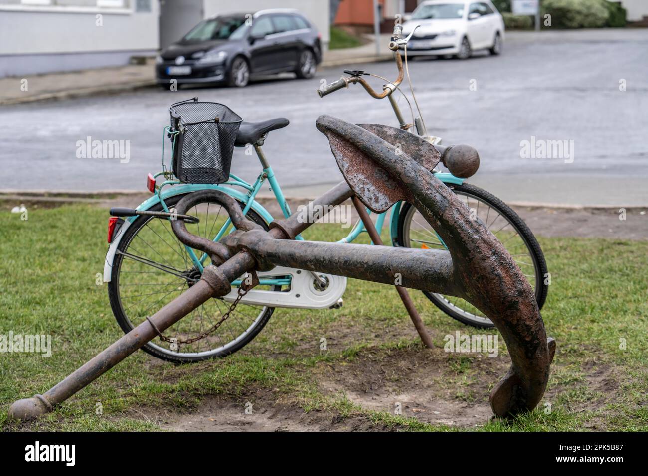 Fahrrad, Damenfahrrad, gut gesichert mit einem Fahrradschloss am Anker eines eisernen Schiffs, in Bremerhaven, Bremen, Deutschland. Stockfoto