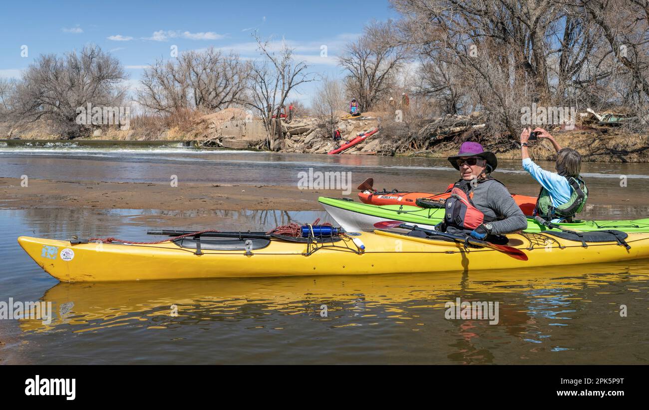 Evans, CO, USA - 1. April 2023: Kajakfahrer ruhen sich aus und fotografieren auf einer Sandbank nach dem Staudamm während einer Paddeltour im Frühling im Süden Stockfoto