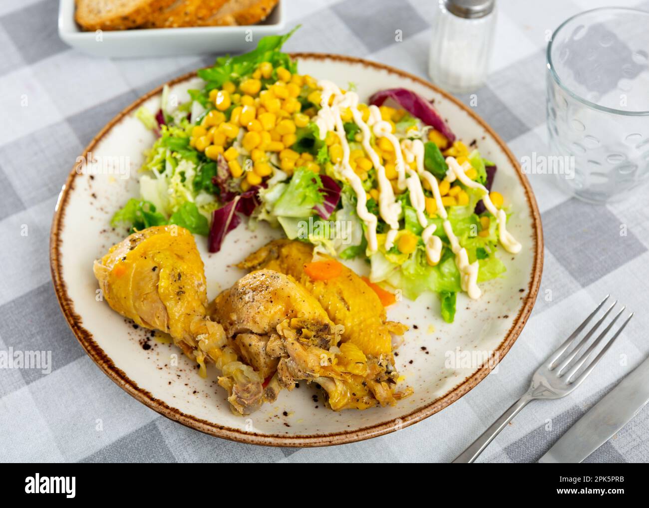 Gebackene Hähnchenteile mit Salat und Mais Stockfoto