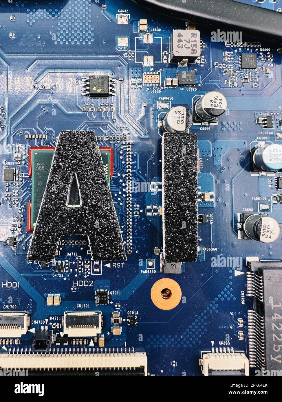 KI-Abkürzung für künstliche Intelligenz in schwarzer Schrift auf einem Notebook-PC-Mainboard, um ein technisches Flair zu vermitteln Stockfoto