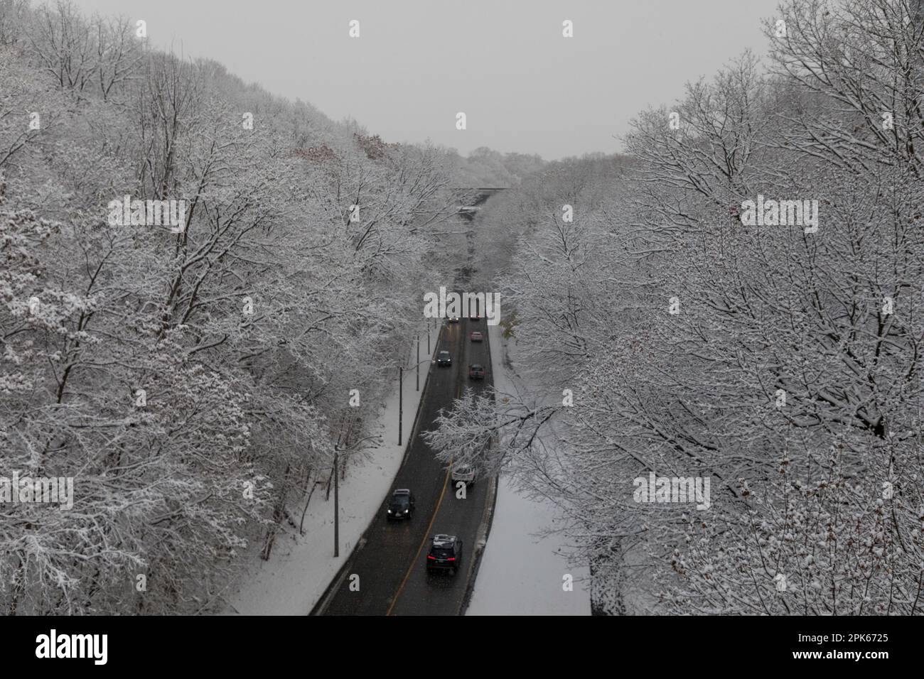 Die Rücklichter von Autos sorgen während des ersten Schneefalls des Winters für Farbakzente auf der Rosedale Valley Road in Toronto, Kanada Stockfoto