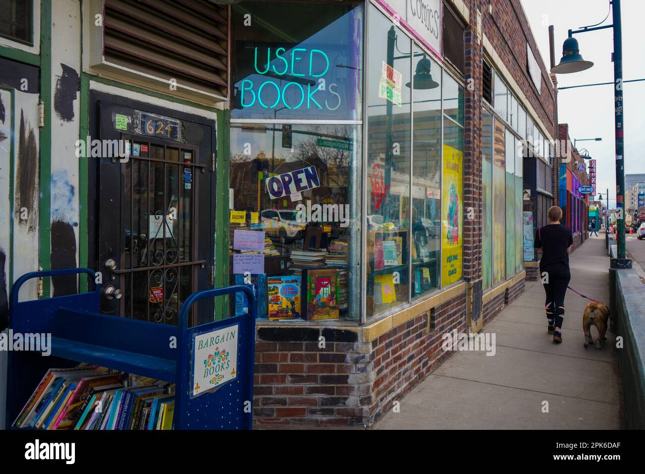 Denver, Colorado - 3,4.2023: Innenstadt, Gebrauchtbuchladen und eine Person mit einem Hund, der vorbeikommt Stockfoto