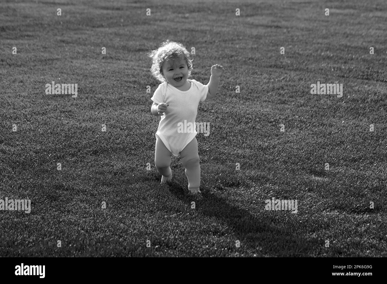 Nette lustige lachende Baby lernen zu kriechen, Spaß am Spielen auf dem Rasen beobachten Sommer im Garten. Glückliche Kindheit und Kinderpflege. Stockfoto