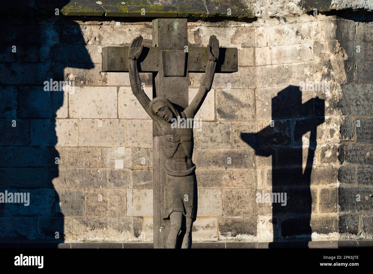 Steinkreuz mit Schattenguss, Dom-Friedhof in der Nähe des Kölner Doms, Köln, Nordrhein-Westfalen, Deutschland Stockfoto