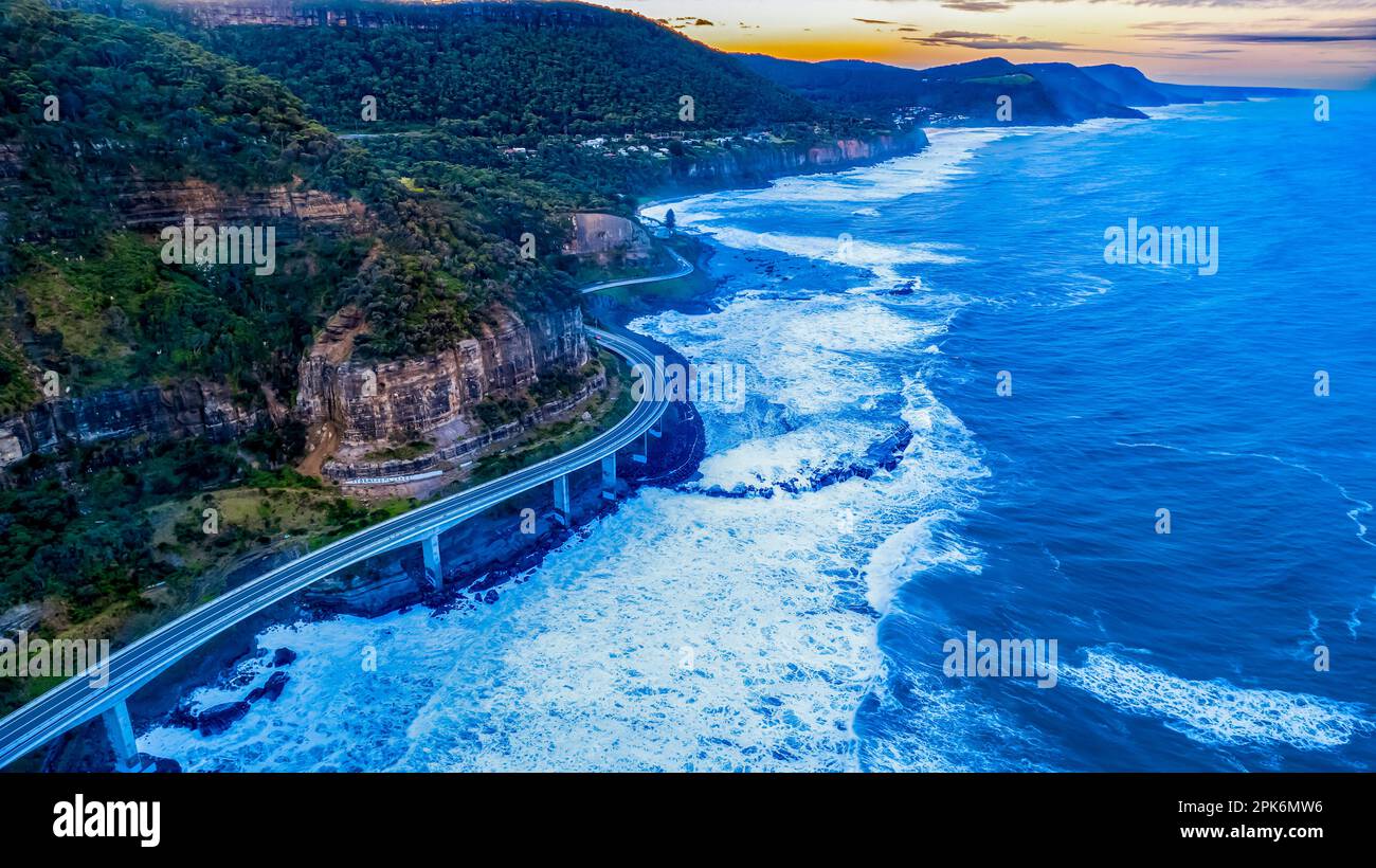 Ein Luftblick auf die Seacliff Bridge entlang der Küste am Pazifischen Ozean in Wollongong, New South Wales, Australien mit Meereswellen. Stockfoto