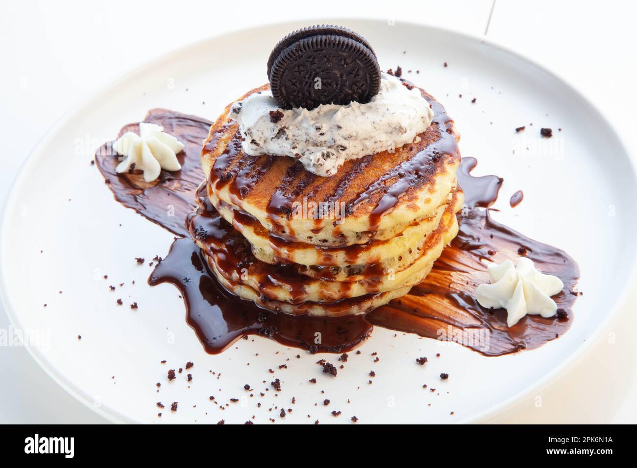 Schokoladen-Pfannkuchen mit Keksen und Sahne. Stockfoto