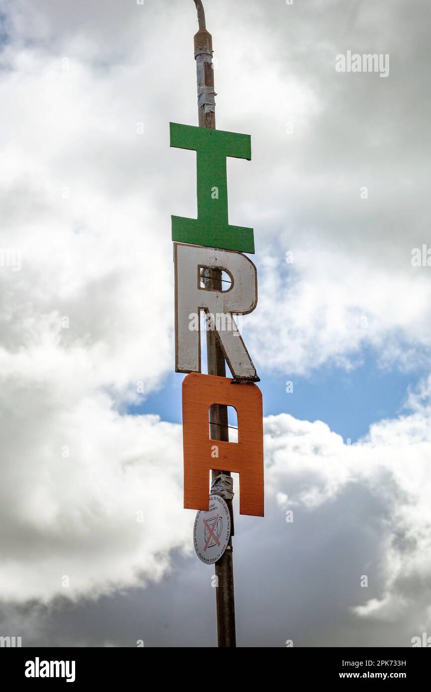 Buchstaben Rechtschreibung I.R.A. ist hoch auf einem Lampenpfahl in West Belfast , Nordirland , zu sehen . Stockfoto