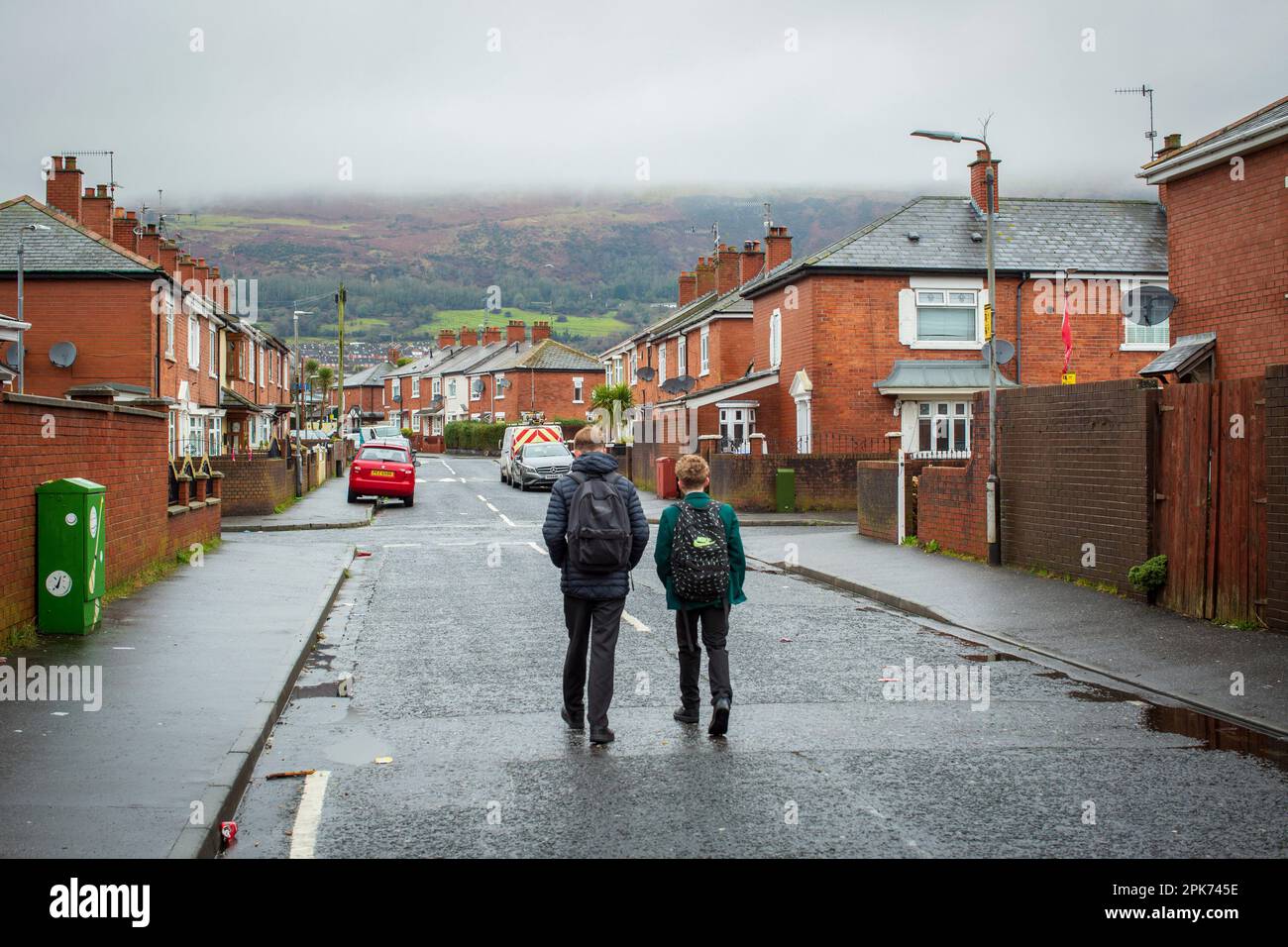 Sekundarschülerinnen und Schüler gehen nach der Schule durch West Belfast, County Antrim, Nordirland, Großbritannien Stockfoto