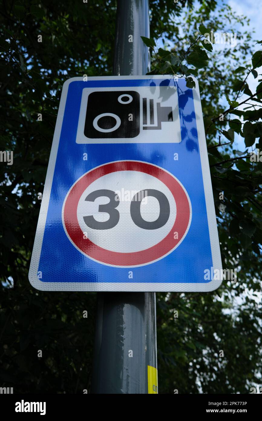 Stark reflektierendes Straßenschild mit 30mph Geschwindigkeitsbegrenzung, das die Fahrgeschwindigkeit im Vereinigten Königreich deutlich anzeigt. Stockfoto