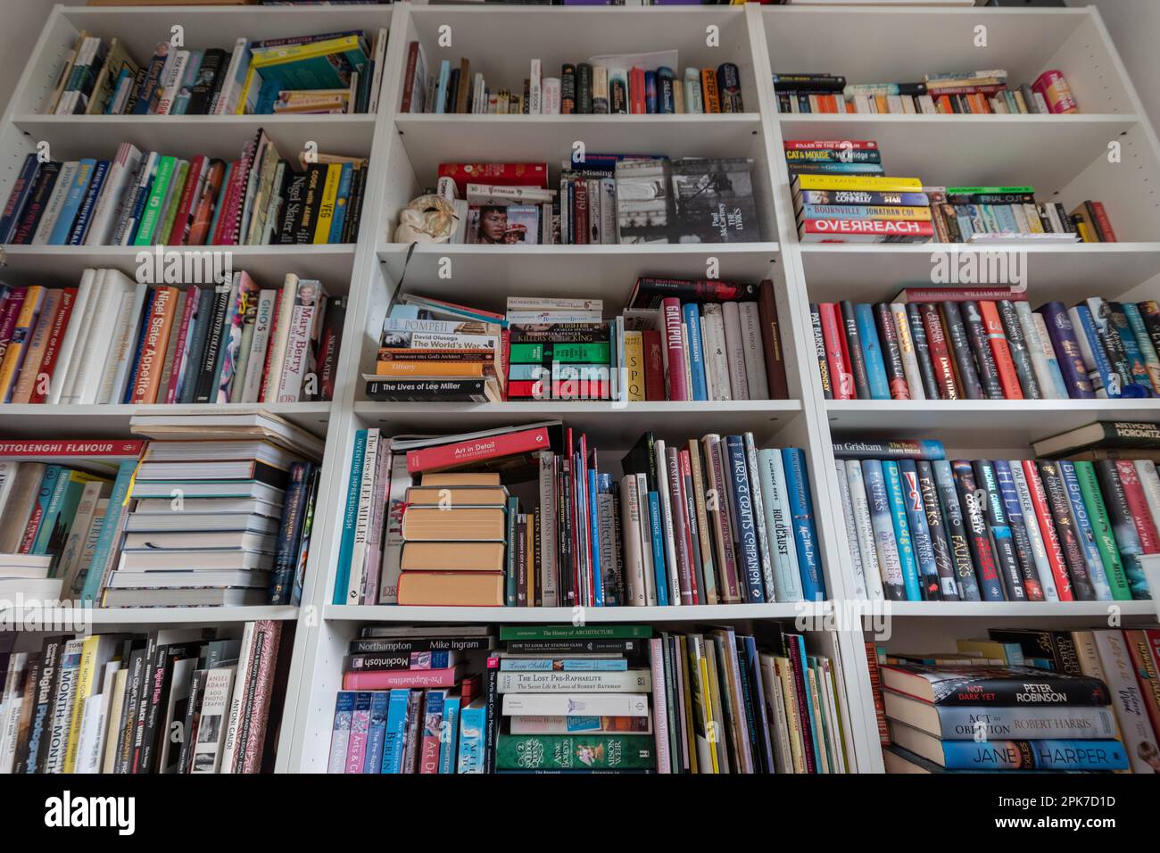 Gut gefüllte weiße hölzerne Bücherregale in einer Hausbibliothek, Großbritannien Stockfoto