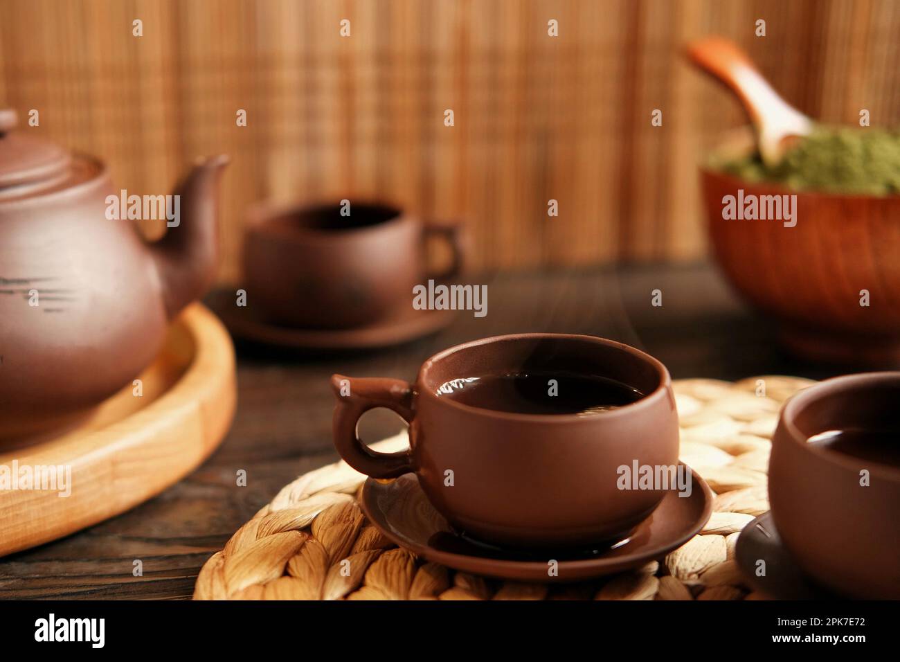 Teezeremonie. Traditionelles Asiatisches Teeutensil, Serviert Authentisches Set. Person, die Tee von der Teekanne aus brauner Keramik bis zur Teekanne einschenkt. Bambusschale. Lifestyle. Wir Stockfoto