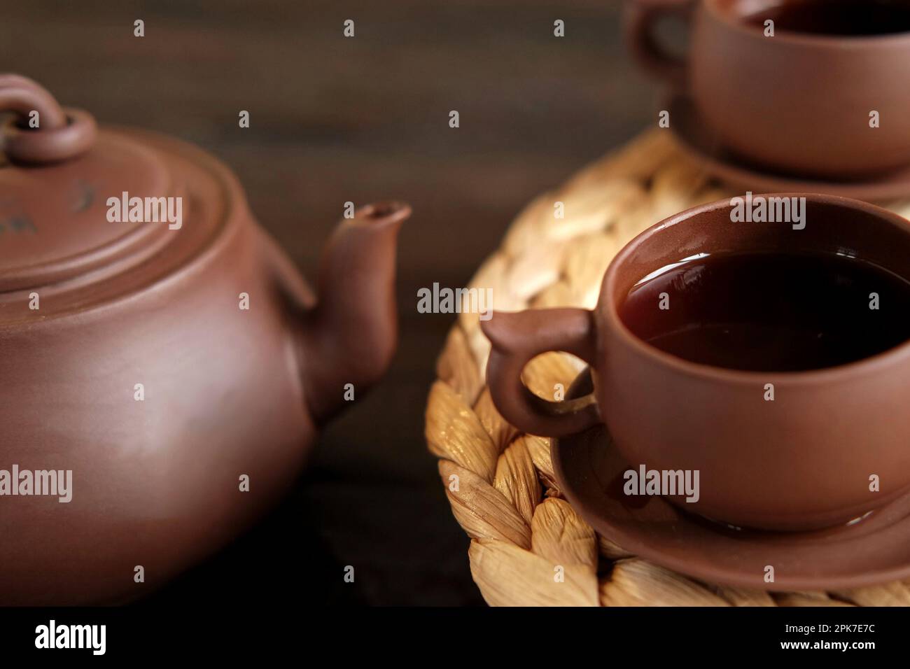 Teezeremonie. Traditionelles Asiatisches Teeutensil, Serviert Authentisches Set. Person, die Tee von der Teekanne aus brauner Keramik bis zur Teekanne einschenkt. Bambusschale. Lifestyle. Wir Stockfoto
