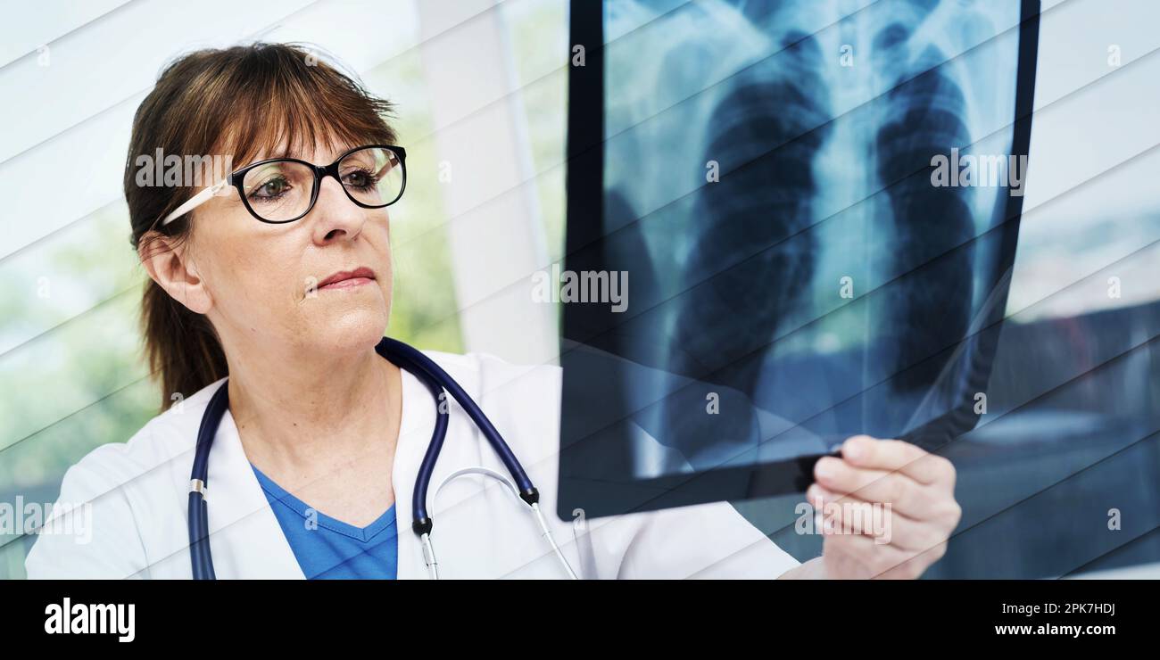 Ärztin untersucht Röntgenbericht in der Praxis, geometrisches Muster Stockfoto