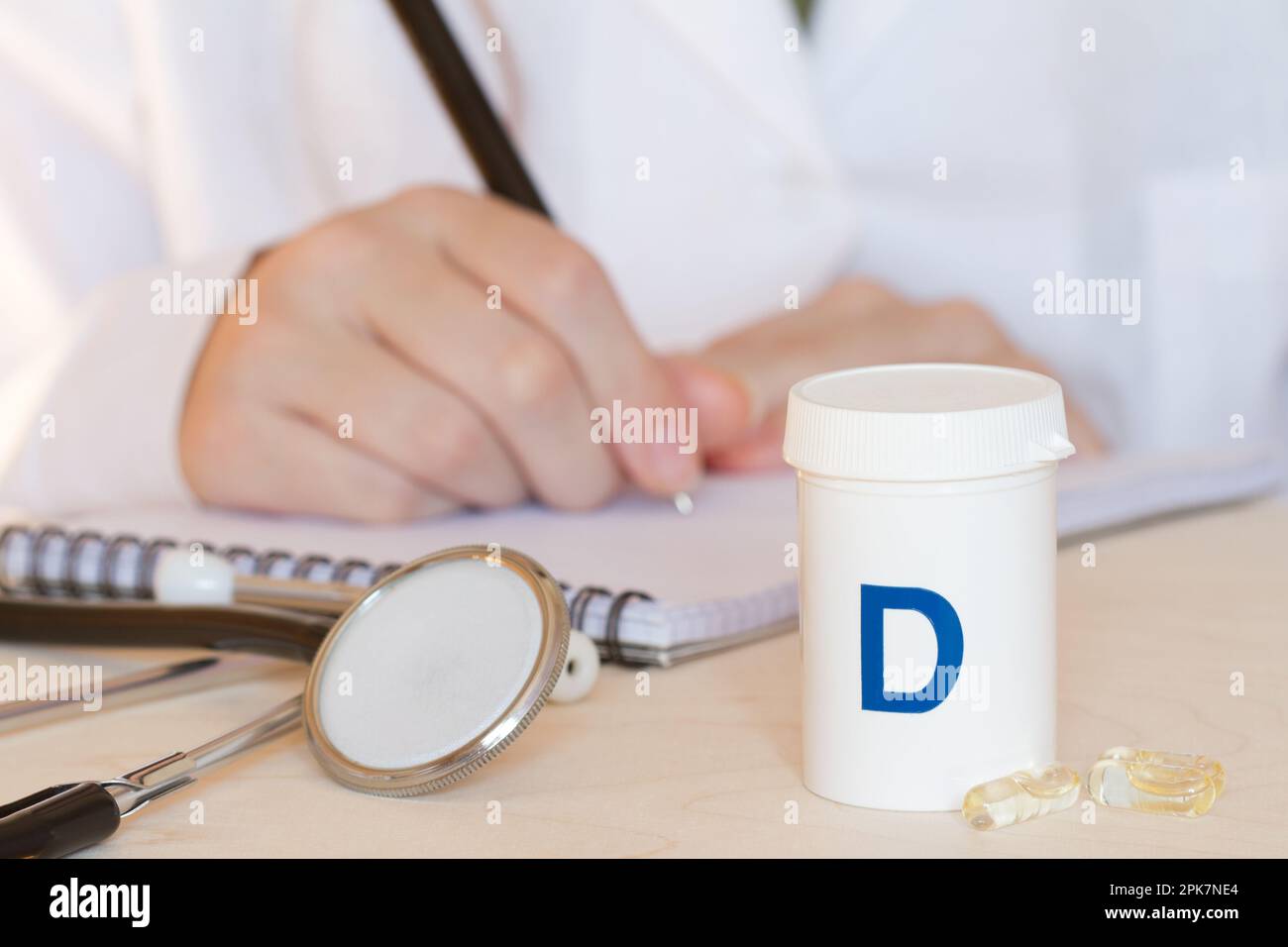 Vitamin D in Kapseln, Stethoskop und Arzt im Hintergrund, Gesundheits- und Immunitätskonzept Stockfoto