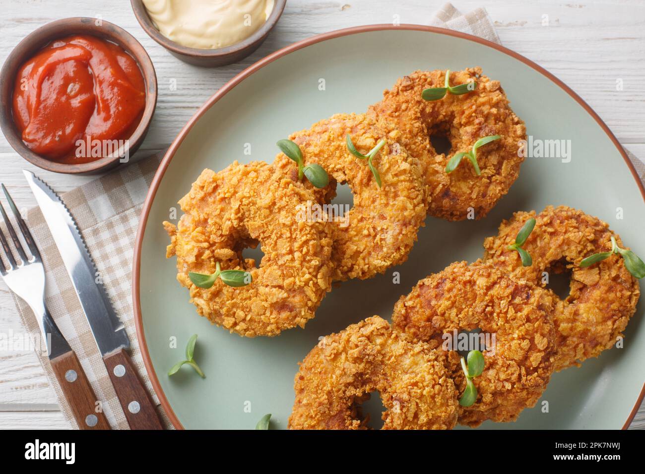 Panierte Hühnchen-Donuts aus gezogenem Hühnchen mit Gemüse und frittierten Nahaufnahmen auf einem Teller auf dem Tisch. Horizontale Draufsicht von oben Stockfoto