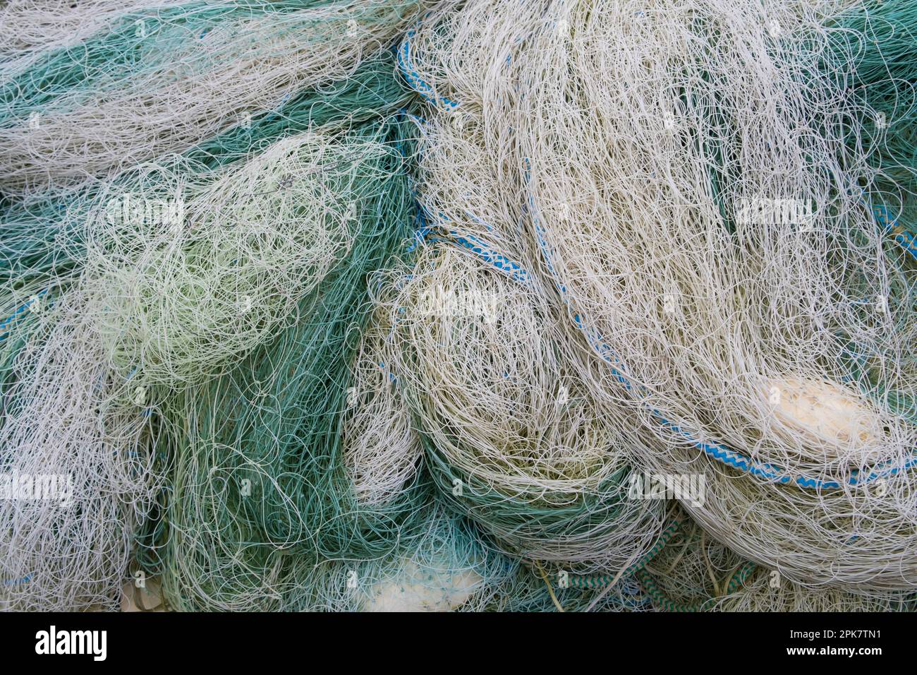 Ein Haufen kommerzieller Fischernetze, blau-grün und weiß. Stockfoto