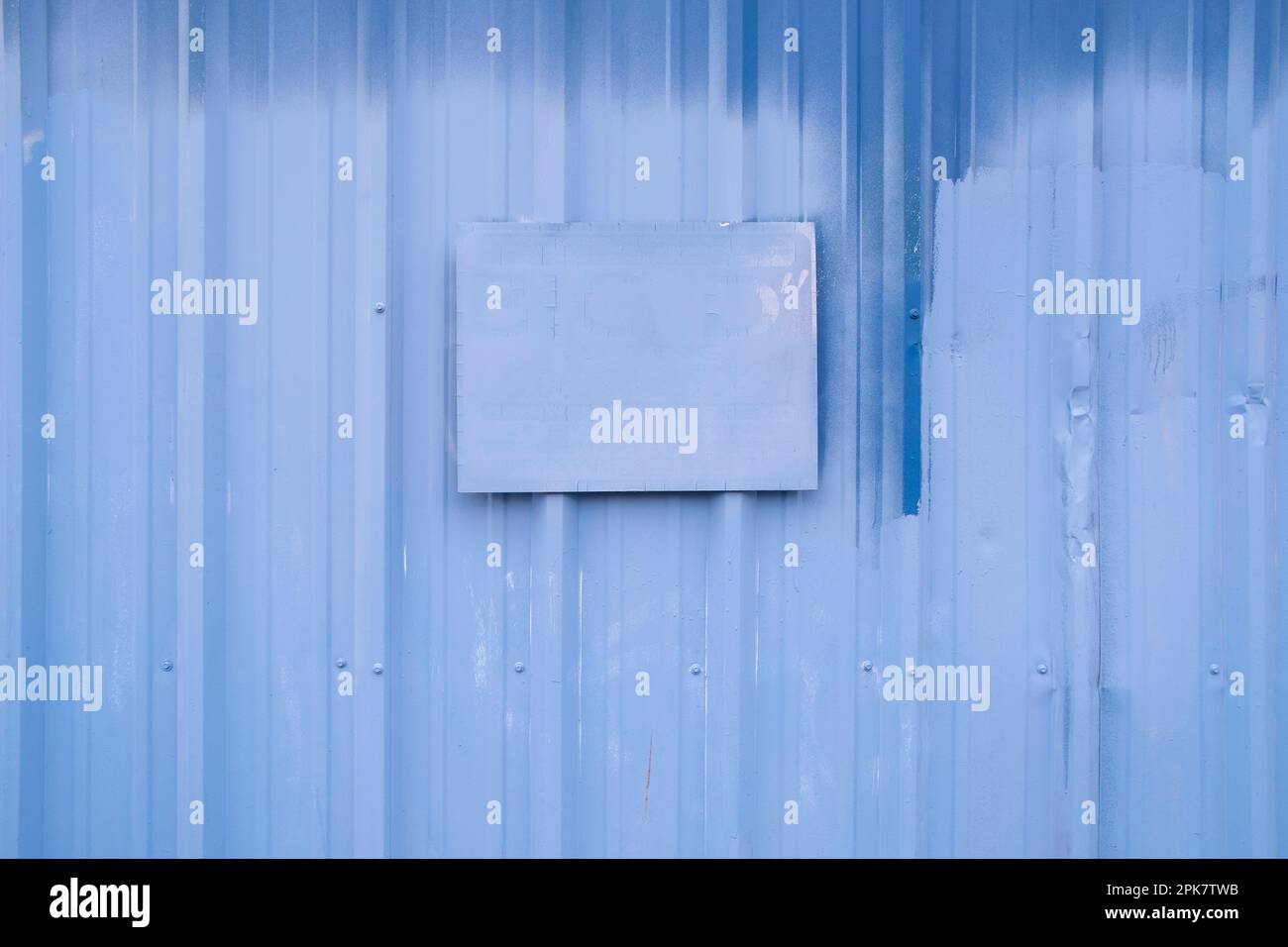 Ein gemaltes Schild an einer blau gestrichenen Gebäudewand. Stockfoto