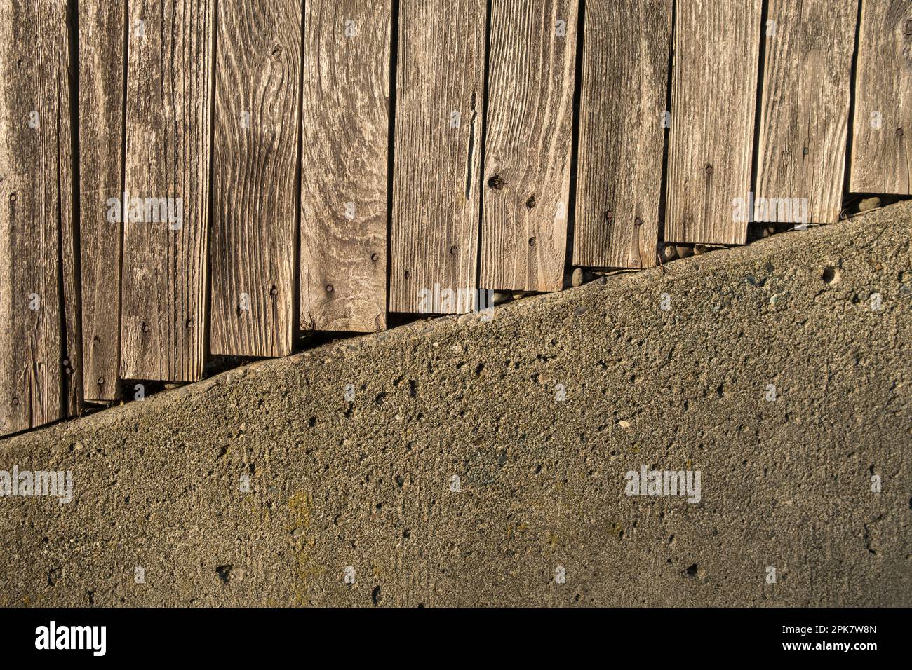 Bretter eines Holzzauns und einer Betonwand. Stockfoto