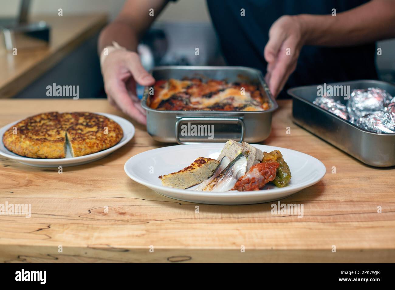 Ein Mann, der Speisen zubereitet, Teller mit italienischem Essen auf einer Restaurantküche. Stockfoto