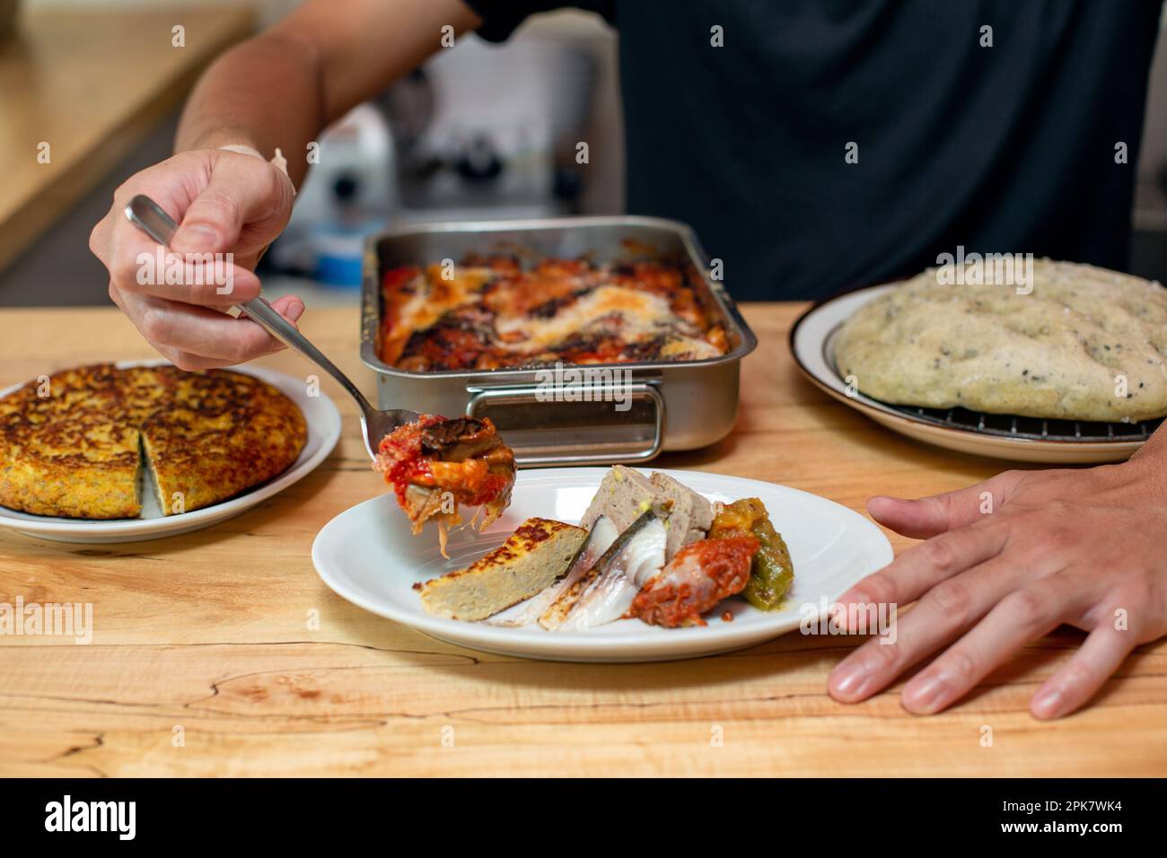 Ein Mann, der Gerichte, Teller mit italienischem Essen zubereitet, auf einem Restaurantschalter. Stockfoto