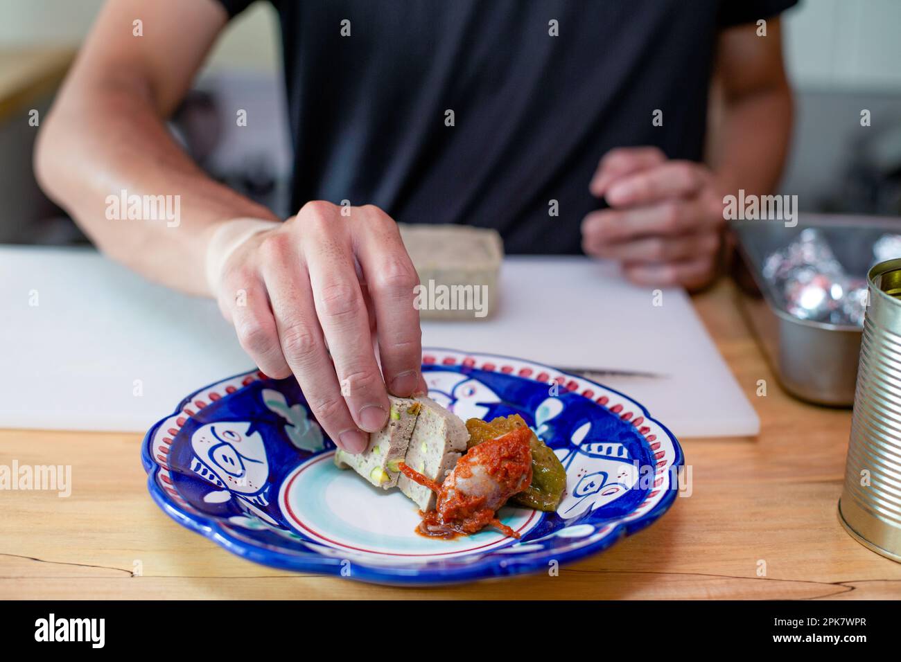 Ein Mann, der in einem Restaurant Essen zubereitet, Gemüse und Pastete auf einen Teller stellt. Schließen. Stockfoto