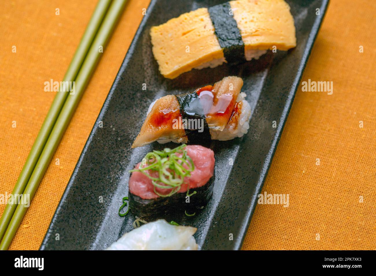 Sushi-Platte, eine Auswahl an rohem Fisch und Reissnacks mit Stäbchen. Stockfoto