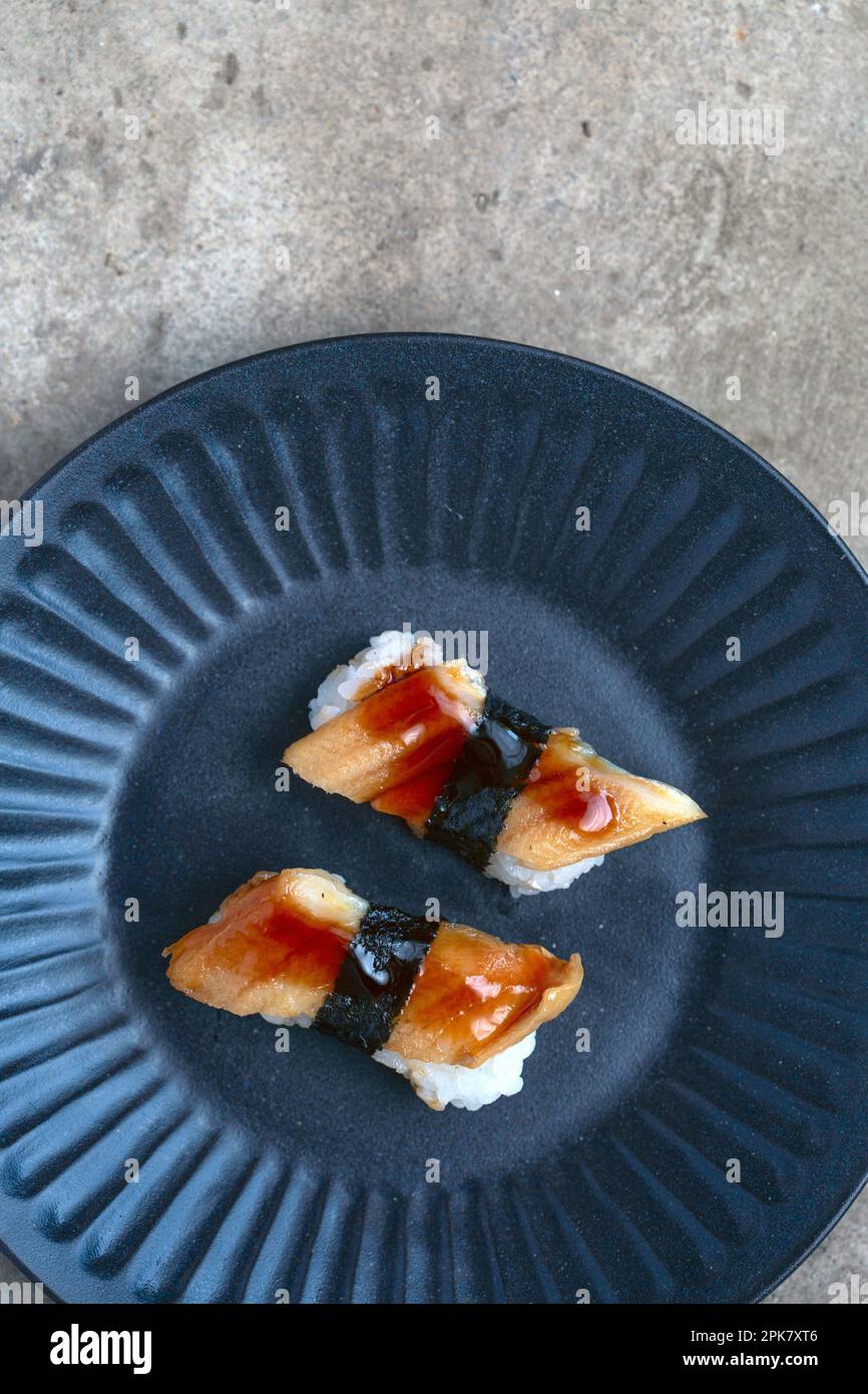 Ein blauer Teller mit frischem Fisch und Seetang. Stockfoto