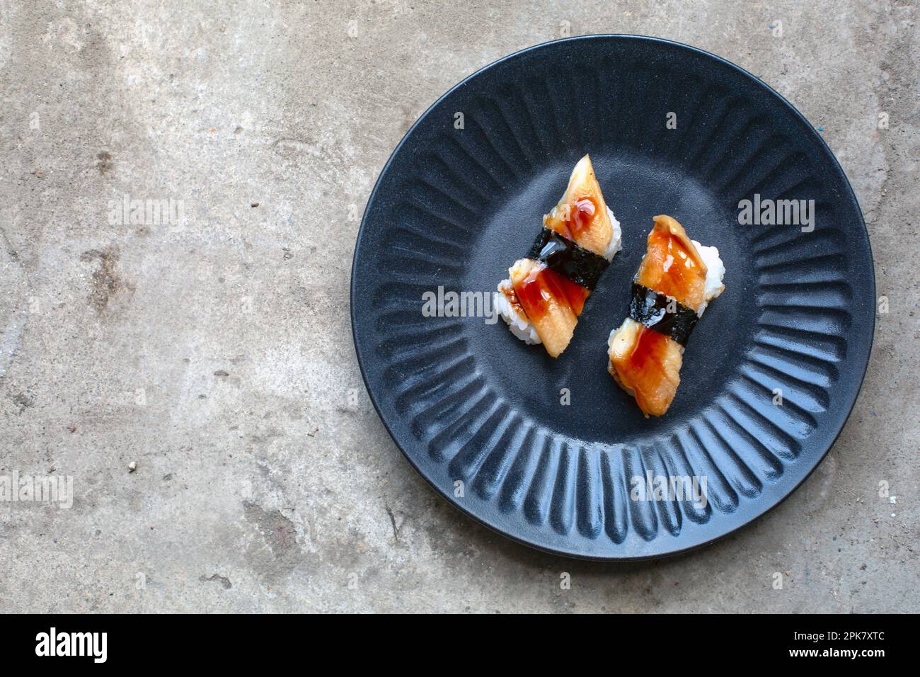 Ein blauer Teller mit frischem Fisch und Seetang. Stockfoto