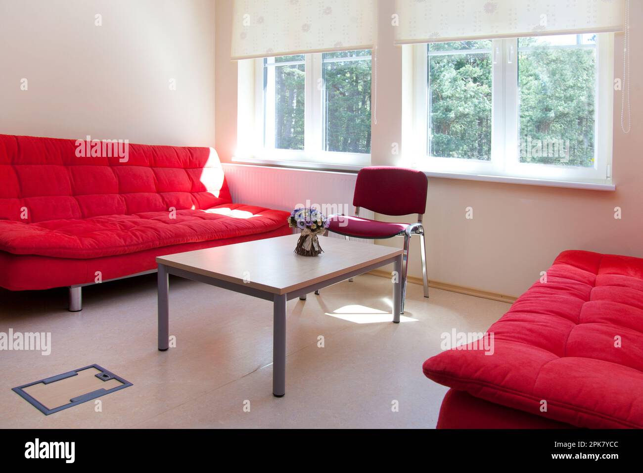 Ein Personalzimmer in einer Schule, zwei rote Sofas und ein Tisch. Stockfoto