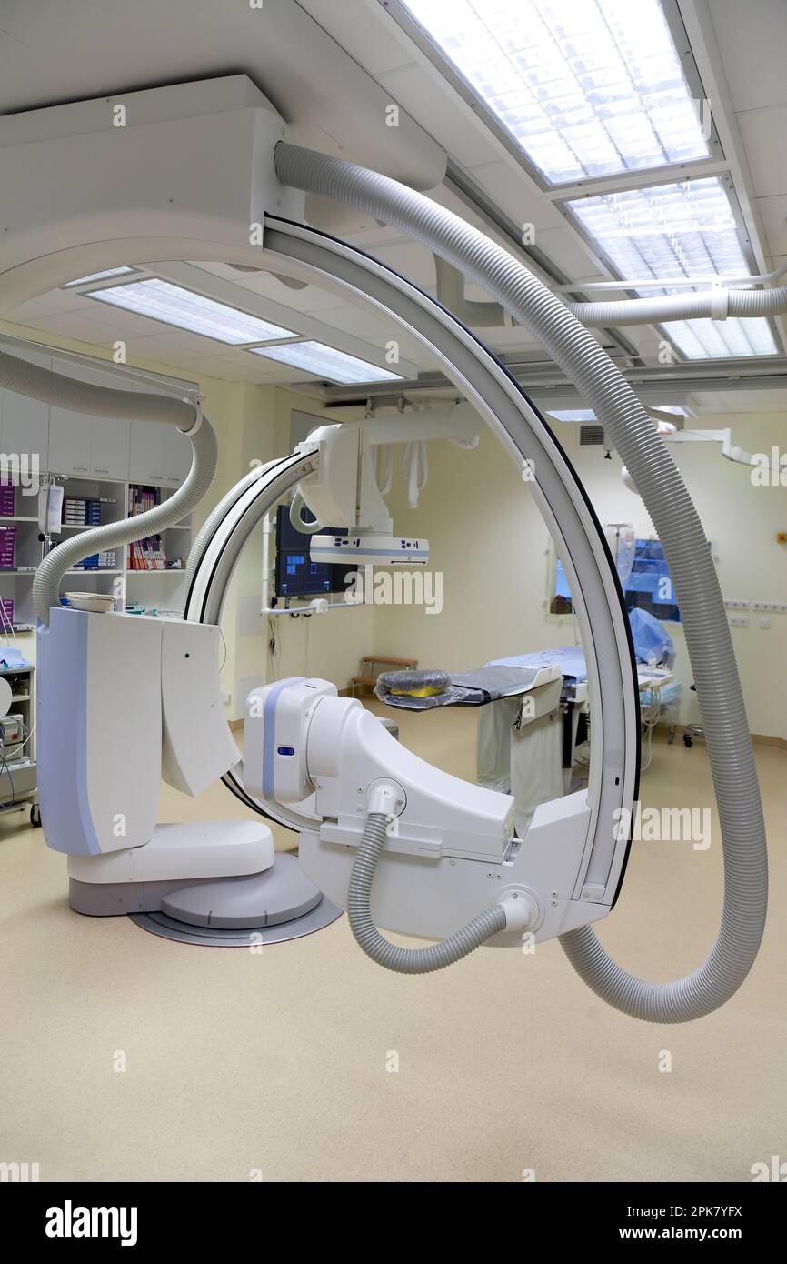 Ein modernes Krankenhauszimmer, ein großes tragbares mobiles Scangerät mit gebogenen Armen, ein mobiler Scanner und eine Krankenwagen oder ein Bett. Stockfoto