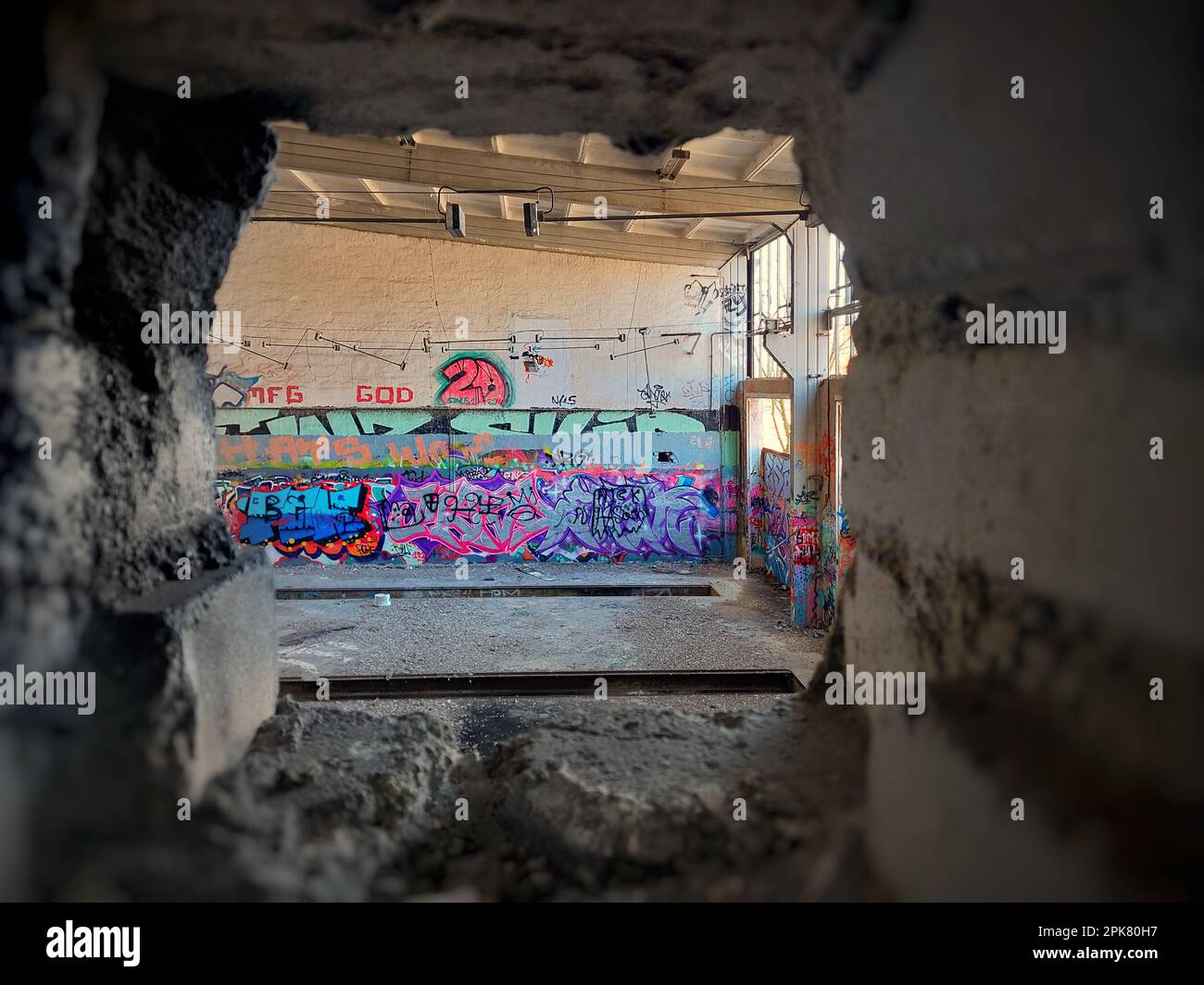 Loch in einer Ziegelwand in einem verlassenen Fabrikgebäude. Stockfoto