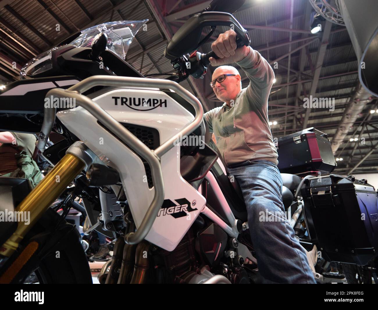 Szenen auf der Carole Nash MCN London Motorcycle Show Excel London, Triumph Stand mit Kunde sitzt auf Triumph Tiger Stockfoto