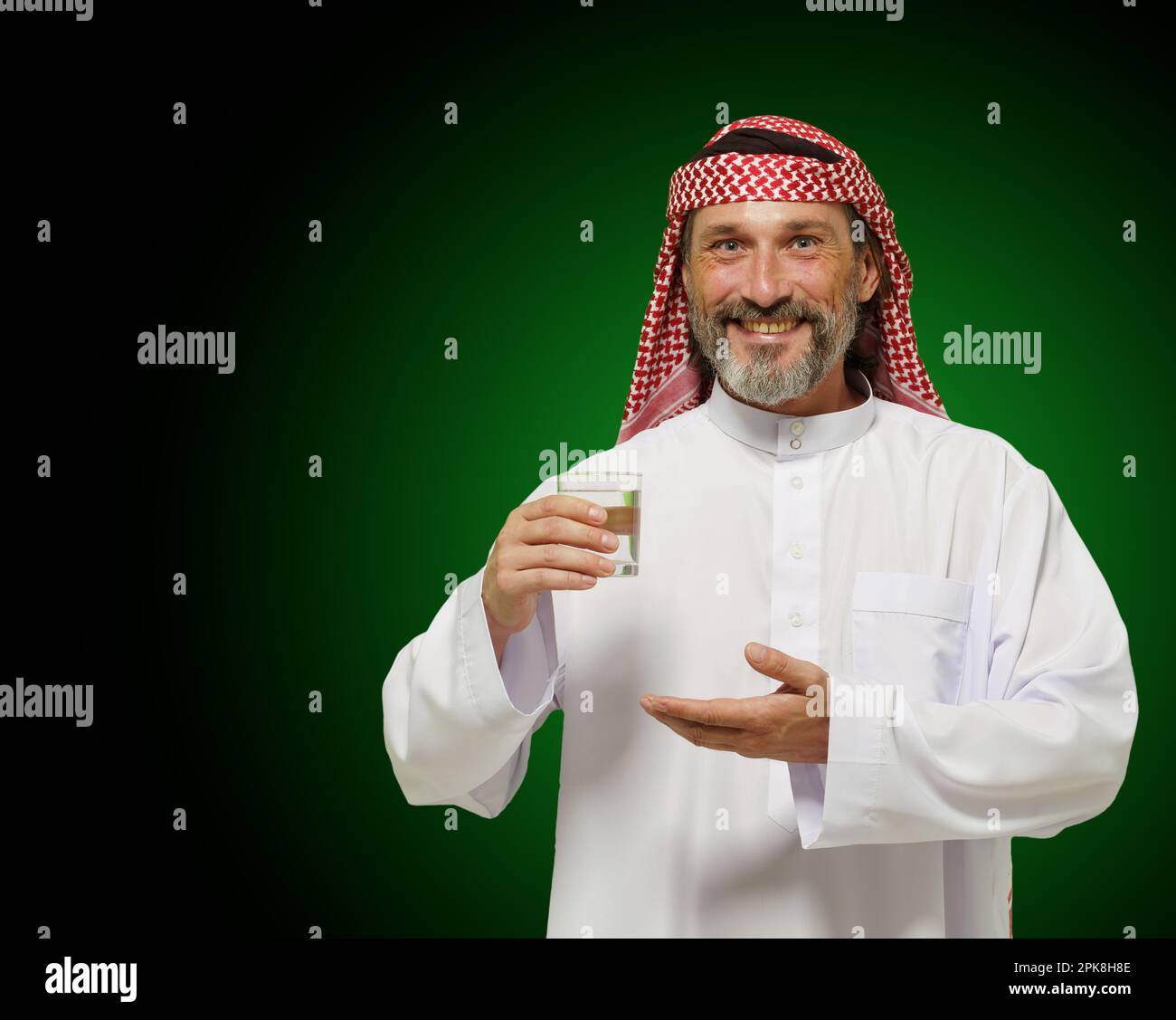 Ein arabischer Mann, der ein Glas Wasser hält und das Gefühl von gesundem Leben und Achtsamkeit vermittelt. Es betont die Bedeutung von Hydration und Wellness in der nahöstlichen Kultur, wodurch es ideal für den Einsatz in der Gesundheit. Hochwertiges Foto Stockfoto