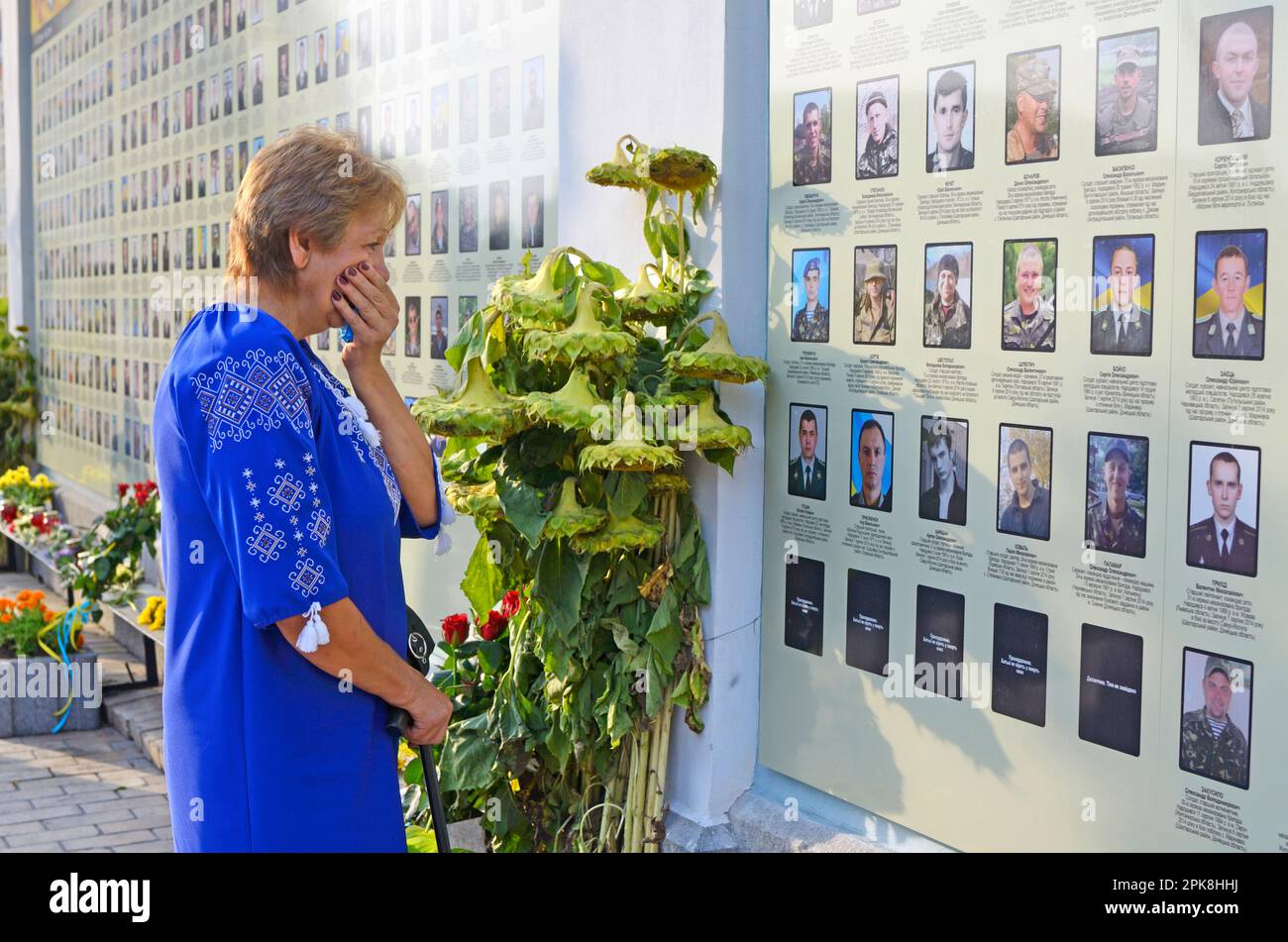 Eine Frau, die vor der Mauer der Erinnerung weinte, legte Blumen. Tagung zum Jahrestag der Schlacht von Ilovaisk (Krieg in Donbass). August 28 Stockfoto