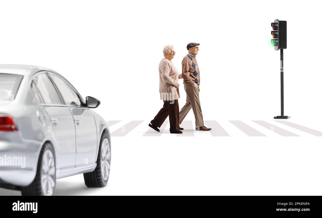 Profilaufnahme eines älteren Mannes und einer älteren Frau, die die Straße überqueren, an einem Fußgängerübergang isoliert auf weißem Hintergrund Stockfoto
