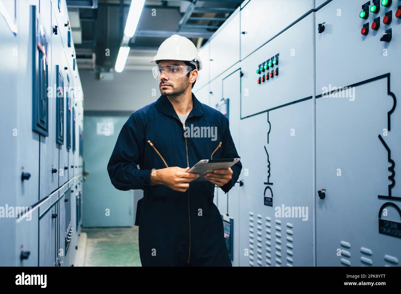Elektriker, der im Werk eine Tablet-Maschine verwendet Stockfoto
