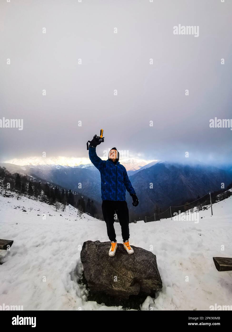 Ein Junge, Selfie-Aufnahme, Action-Kamera, Stein, stehend, Berglandschaft, Winter, Stockfoto